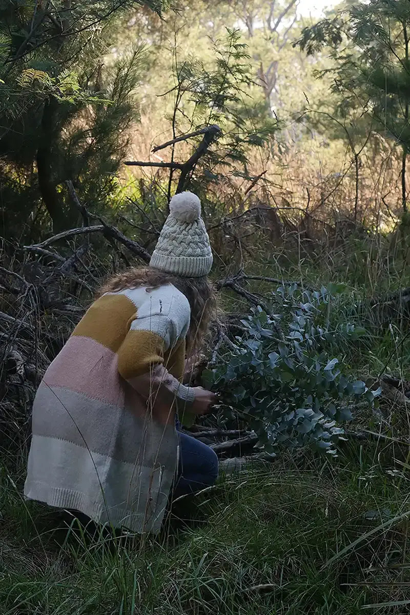 Model inspecting the wild flowers in the bush