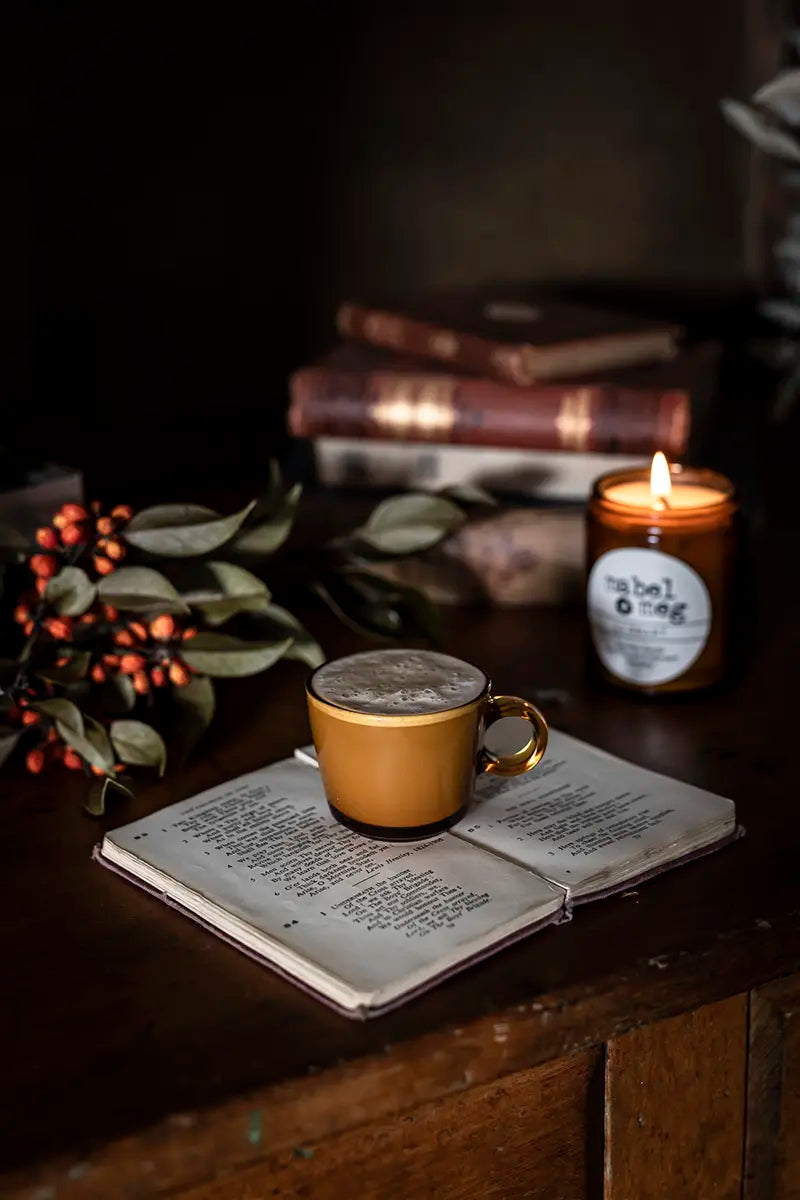 Scented Candle by Mabel + Meg in Library Classic on desk with coffee and book