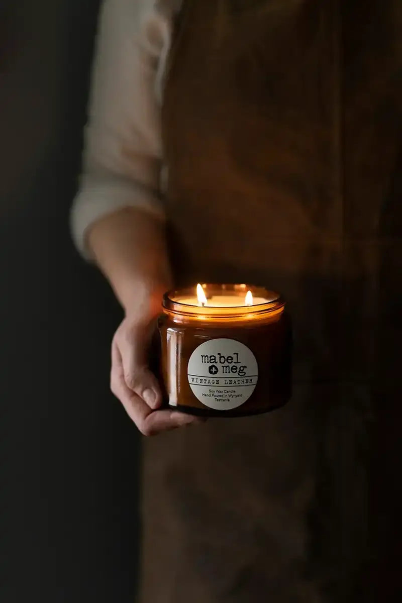 Scented Candle by Mabel + Meg in Vintage Leather XL alight in the hands of the artisan