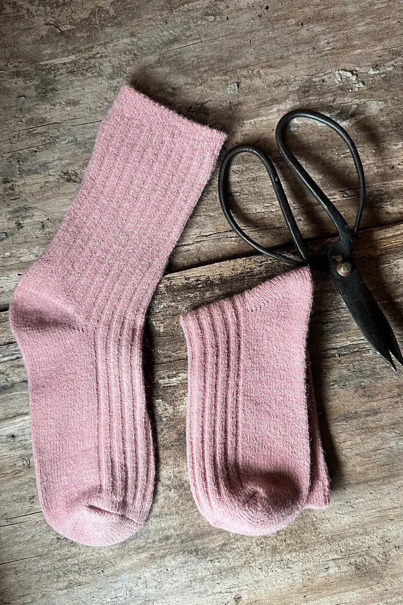 Wool Blend Crew Socks in Pink by Mabel + Meg pair with one folded and sewing scissors on bench